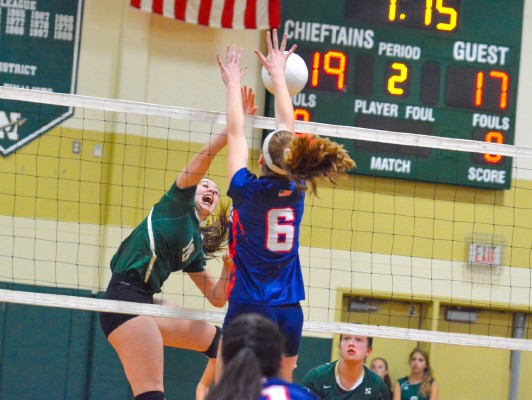 Nashoba junior middle hitter Brynne McConnell spikes the ball past the outstretched arms of North MiddlesexÕs Maddy Harrington during Saturday morningÕs match in Bolton.  	SENTINEL & ENTERPRISE / ED NISER