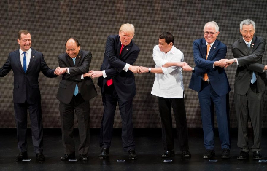 President Trump shaking hands with Philippine President Rodrigo Duterte, third from right, and other leaders.